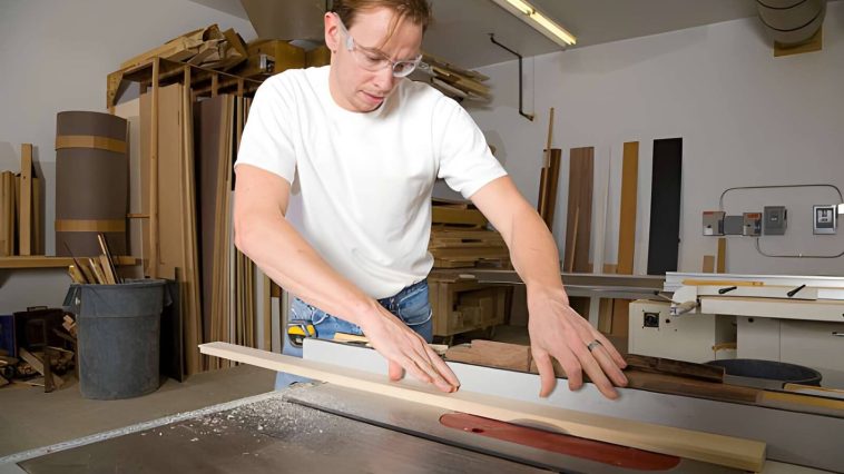 a man using a cross cut sled in the shop