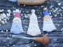 Three flat Scandinavian-style carved Santa ornaments on a dark wooden surface