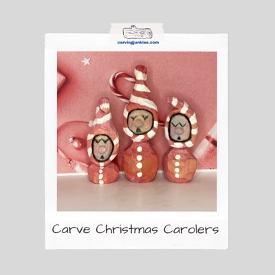 A group of hand-carved Christmas carolers painted in pink and white