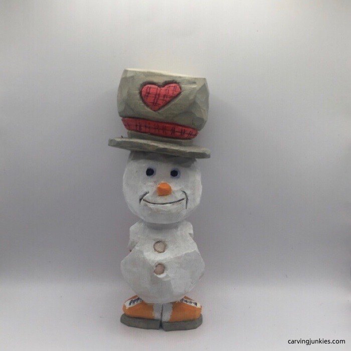 White carved snowman with a tilted top hat and orange ice skates