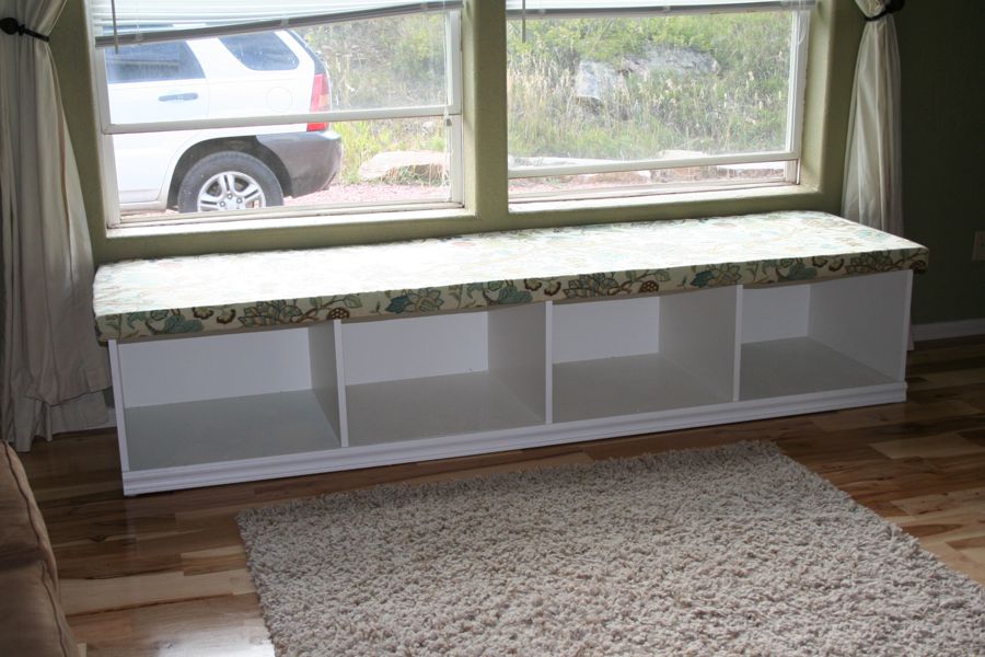 Reader-built white window seat with open book cubbies and a patterned cushion
