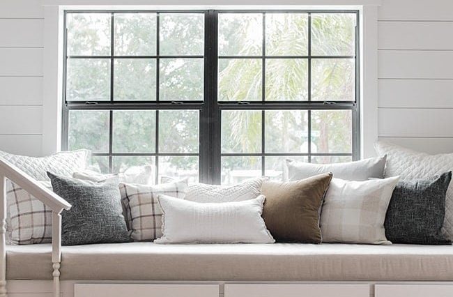 White built-in reading bench with three drawers below a window