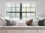 White built-in reading bench with three drawers below a window