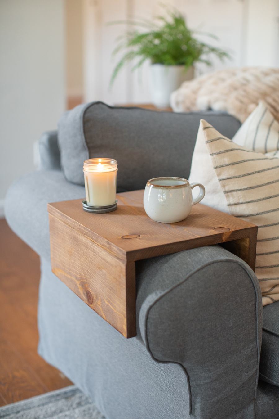 Wide pine sofa arm tray on a gray couch