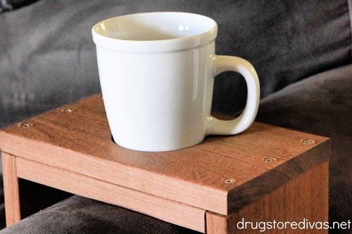Hardwood couch sleeve with a mug in its cup opening